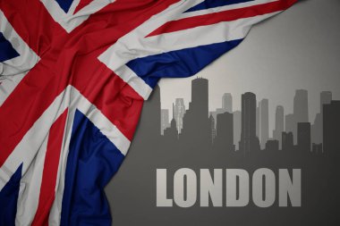 Şehrin soyut silueti. Üzerinde yazı var. Londra, gri bir arkaplanda İngiltere bayrağı sallıyor..