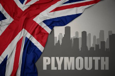 Şehrin soyut silueti. Üzerinde Plymouth yazıları var. Gri bir arkaplanda büyük Britanya bayrağı dalgalandırıyor..