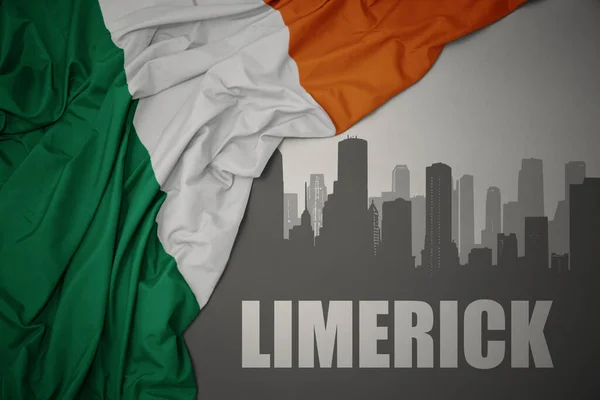 利默里克在灰色背景下飘扬着五彩缤纷的爱尔兰国旗 用文字勾勒出城市的轮廓 — 图库照片