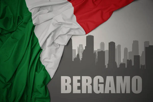 イタリアのカラフルな国旗を灰色の背景に振っているベルガモという街の抽象的なシルエット — ストック写真