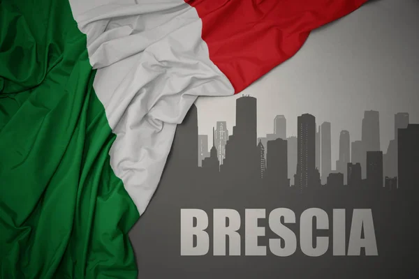 灰色の背景にイタリアのカラフルな国旗を振って近くのテキストブレシアと街の抽象的なシルエット — ストック写真