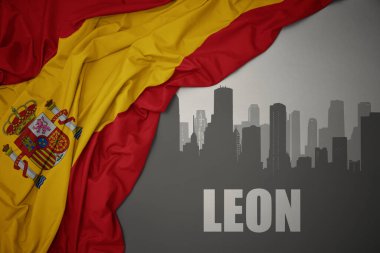 Şehrin soyut silueti. Leon, gri bir arka planda renkli İspanya bayrağı sallıyor..