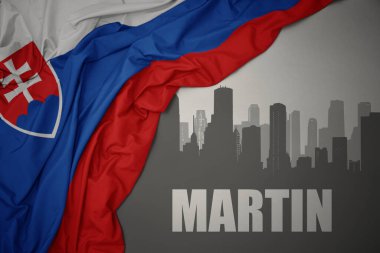 Şehrin soyut silueti. Martin, gri bir arkaplanda renkli bir slovakya bayrağı sallıyor..