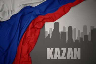 Rusya 'nın gri arka planında renkli bayrağını dalgalandıran Kazan' ın mesajlarıyla şehrin soyut silueti.