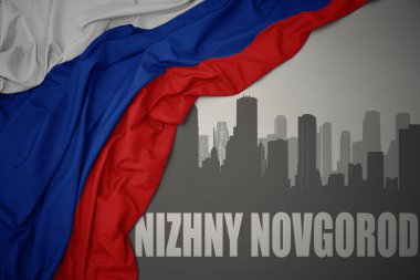 Nizhny Novgorod 'un gri arka planda renkli Rusya bayrağı dalgalanması yakınındaki yazılarıyla şehrin soyut silueti.