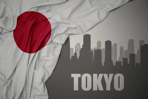日本のカラフルな国旗を灰色の背景に振っている東京の抽象的なシルエット — ストック写真