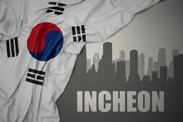 灰色の背景に韓国のカラフルな国旗を振って近くにテキスト仁川市の抽象的なシルエット — ストック写真