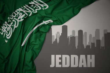 Kentin soyut silueti, gri bir arka planda Suudi Arabistan 'ın renkli bayrağının dalgalanması yakınındaki Jeddah yazısıyla..