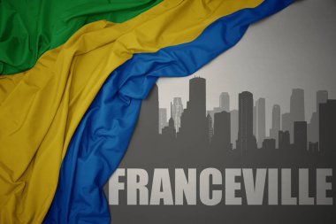 Kentin soyut silueti ve gri arka planda renkli bir gabon bayrağı dalgalandıran Franceville yazısı. 3B illüstrasyon