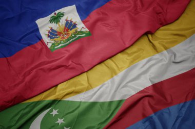 waving colorful flag of comoros and national flag of haiti. macro.3d illustration