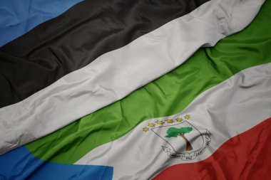 waving colorful flag of equatorial guinea and national flag of estonia. macro.3d illustration