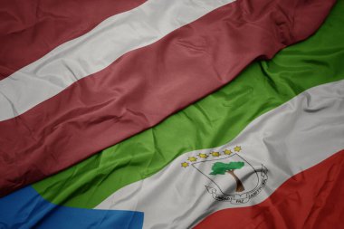 waving colorful flag of equatorial guinea and national flag of latvia. macro.3d illustration