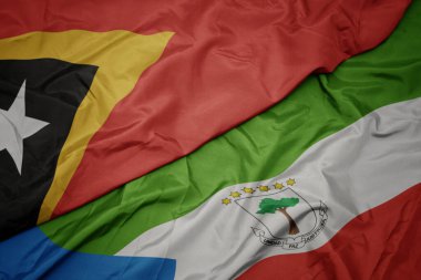 waving colorful flag of equatorial guinea and national flag of east timor. macro.3d illustration