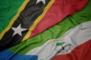 waving colorful flag of equatorial guinea and national flag of saint kitts and nevis. macro.3d illustration