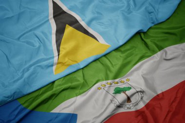 waving colorful flag of equatorial guinea and national flag of saint lucia. macro.3d illustration