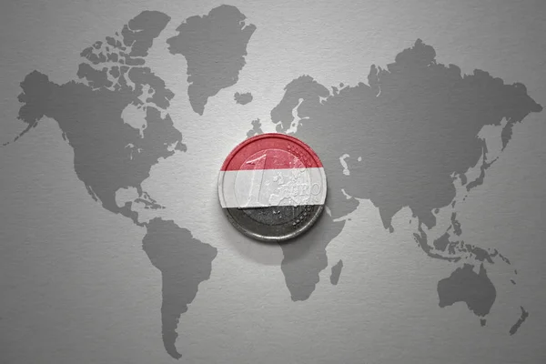 グレーの世界地図の背景にイエメンの国旗を持つユーロコイン 金融の概念 — ストック写真