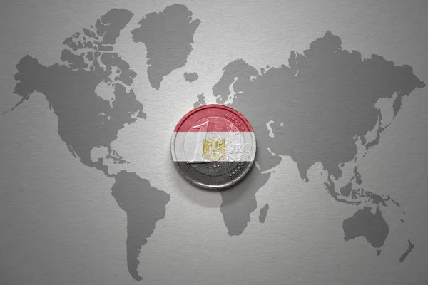 灰色の世界地図の背景にエジプトの国旗を持つユーロコイン 金融の概念 — ストック写真