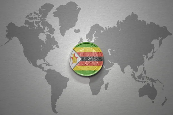 灰色の世界地図の背景にジンバブエの国旗を持つユーロ硬貨 金融の概念 — ストック写真