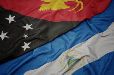 Papua Yeni Gine 'nin renkli bayrağı ve Nikaragua' nın ulusal bayrağı sallanıyor. Makro. 3d illüstrasyon