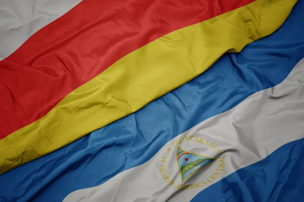 Viftande Färgglada Flagga Södra Ossetien Och Nationell Flagga Nicaragua Makro — Stockfoto