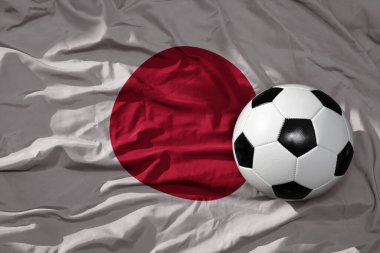 Japonya 'nın arka planında sallanan eski bir futbol topu. 3B illüstrasyon