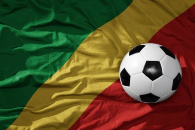 Kongo arka planında sallanan ulusal bayrağın üzerinde eski, klasik bir futbol topu. 3B illüstrasyon