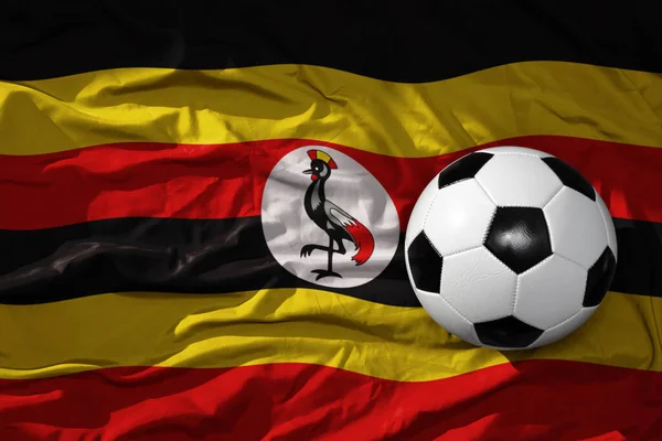 ウガンダの国旗を背景にした古くからのヴィンテージサッカーボールです 3Dイラスト — ストック写真