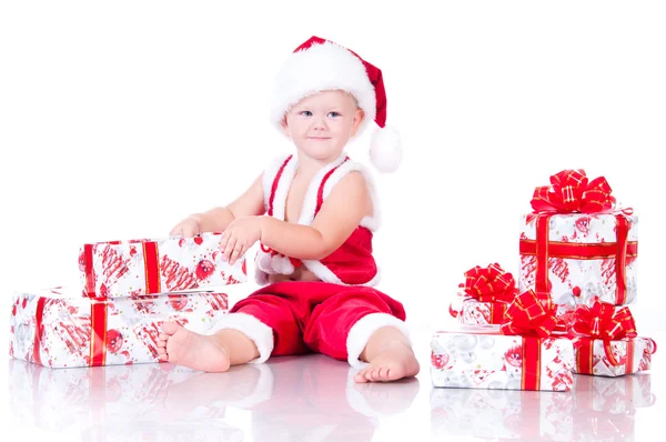 Маленький мальчик Санта-Клаус с рождественскими подарками на белой спине — стоковое фото