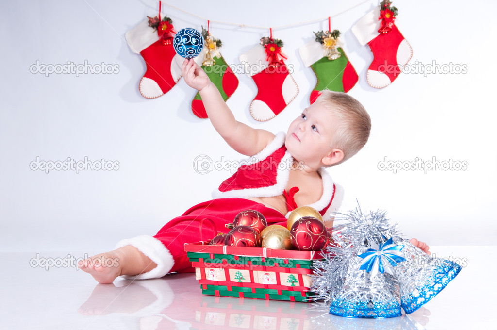 Cute baby Santa Claus with garlands and a basket of Christmas to