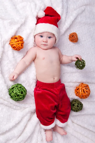 Petit Père Noël avec des jouets couchés sur un fond blanc . — Photo