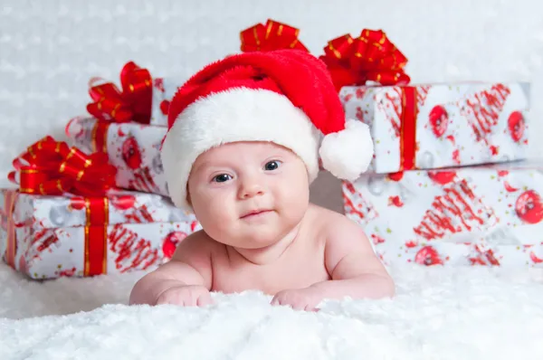 Новорожденный мальчик Санта Клаус с рождественскими подарками Стоковое Фото