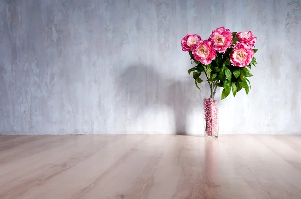 Bouquet of peonies in a vase against a blue wall. Interior. — Stock Photo, Image