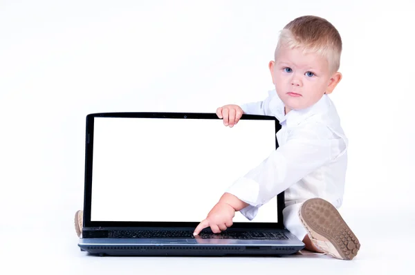 Little business boy in solid white suit sitting at notebook on Stock Photo