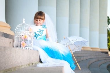 küçük gelin. yemyeşil düğün beyaz ve mavi elbiseli bir kız ve