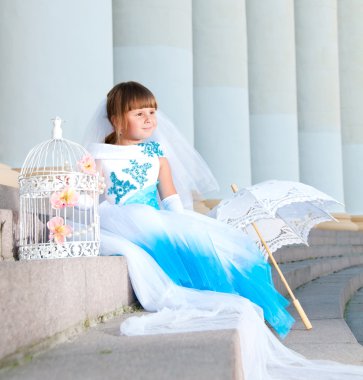 küçük gelin. yemyeşil düğün beyaz ve mavi elbiseli bir kız ve