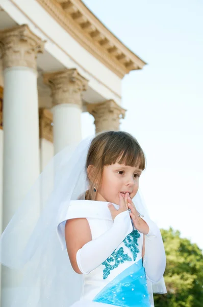 Pequena noiva. Uma menina em um vestido de noiva branco e azul exuberante e — Fotografia de Stock