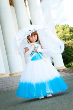 küçük gelin. yemyeşil düğün beyaz ve mavi elbiseli bir kız ve