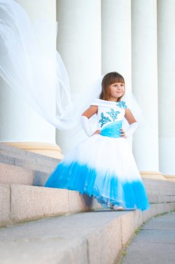 küçük gelin. yemyeşil düğün beyaz ve mavi elbiseli bir kız ve