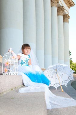 küçük gelin. yemyeşil düğün beyaz ve mavi elbiseli bir kız ve