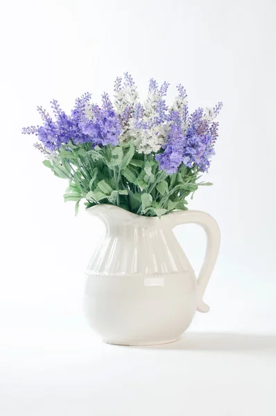 Flores silvestres en un jarrón blanco sobre un fondo blanco . —  Fotos de Stock