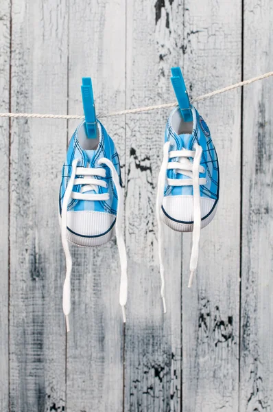 Chaussures de bébé accrochées à la corde à linge. — Photo