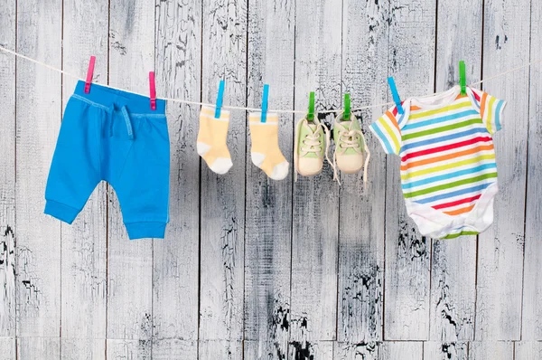 De kleren van de baby opknoping op de waslijn. Rechtenvrije Stockafbeeldingen