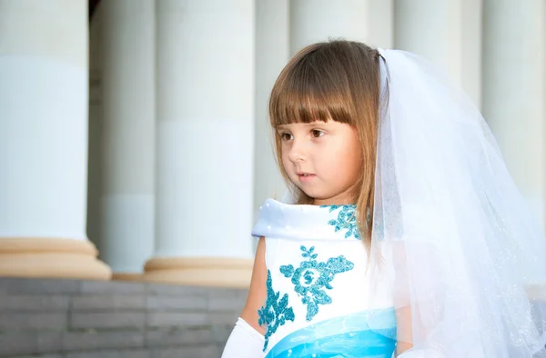 Pequena noiva. Uma menina em um vestido de noiva branco e azul exuberante e — Fotografia de Stock