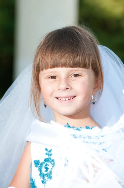 Pequena noiva. Uma menina em um vestido de noiva branco e azul exuberante e — Fotografia de Stock