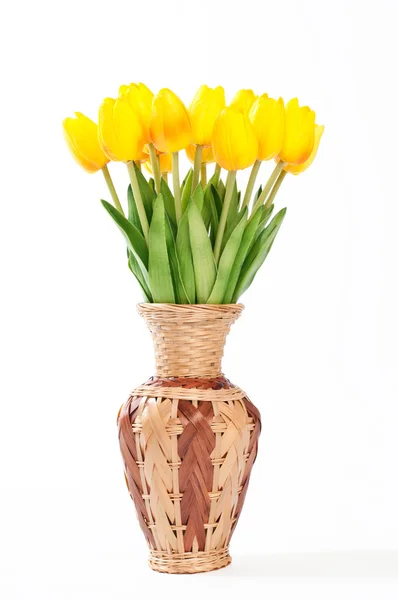 Yellow tulips in a wicker vase on a white background. — Stock Photo, Image