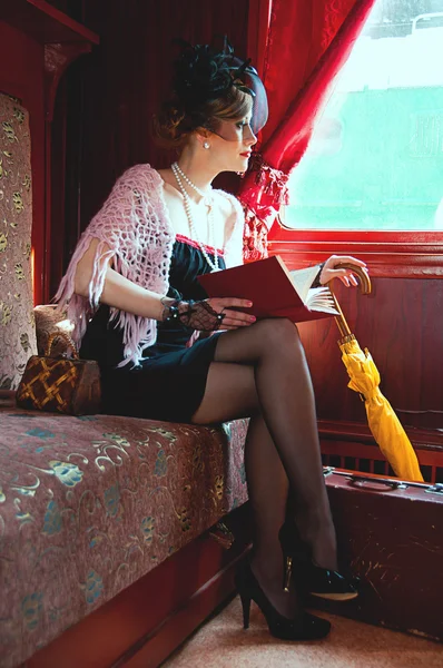 Retro girl reading book in wagon train — Stock Photo, Image