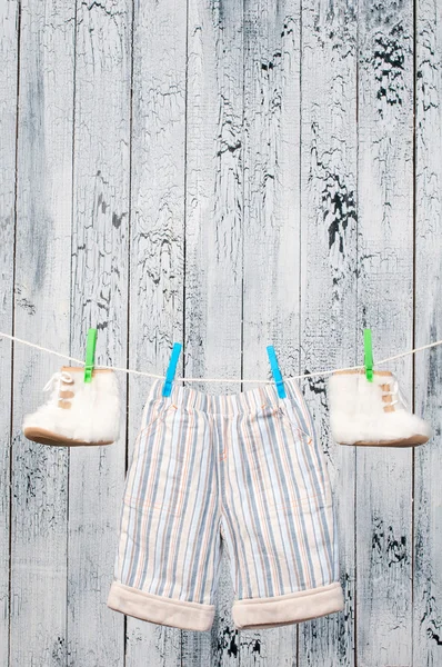 Kinderstiefel hängen an einer Wäscheleine. — Stockfoto