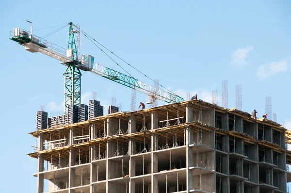 Construction d'un immeuble de grande hauteur avec une grue sur le fond du ciel . — Photo