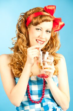 Portrait coquettish Lovely redhead pin-up girl drinks a drink fr