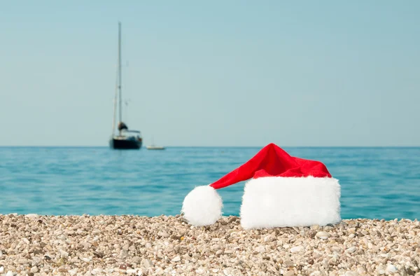 Weihnachtsmütze liegt am Strand. — Stockfoto